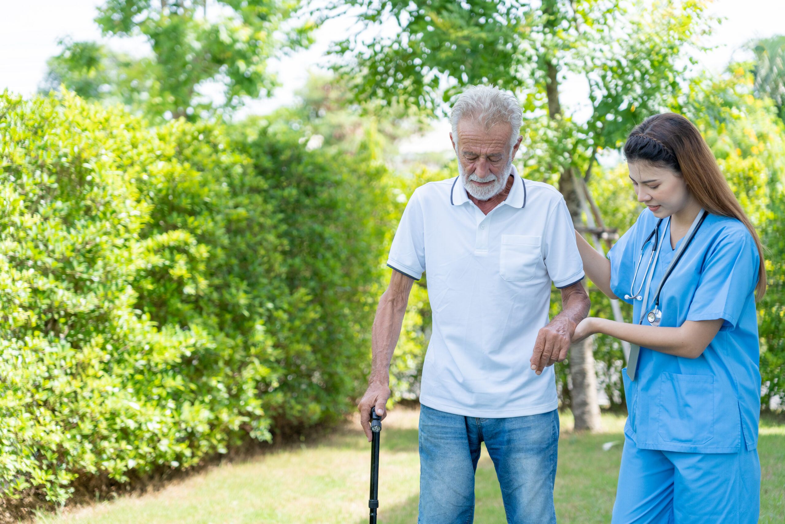 nurse helping elderly man to walk