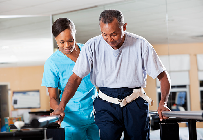 A nurse assisting a man in therapy.