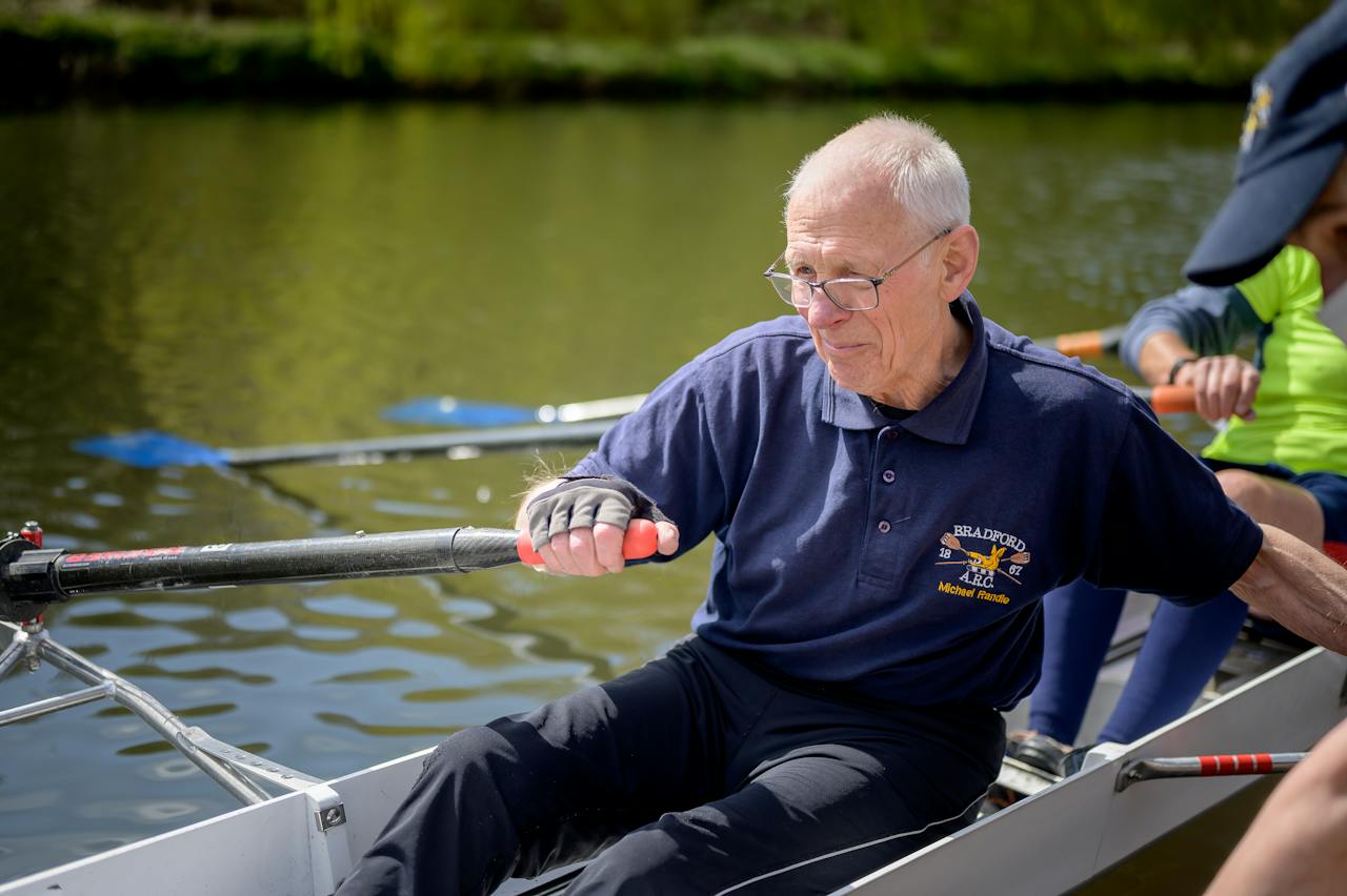An elderly man paddle a boat